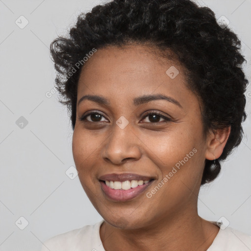 Joyful black young-adult female with short  black hair and brown eyes