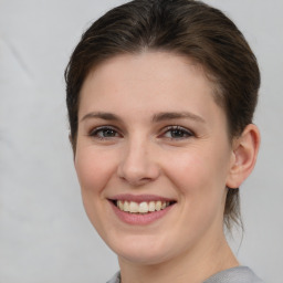 Joyful white young-adult female with medium  brown hair and grey eyes