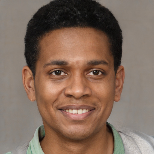 Joyful latino young-adult male with short  black hair and brown eyes