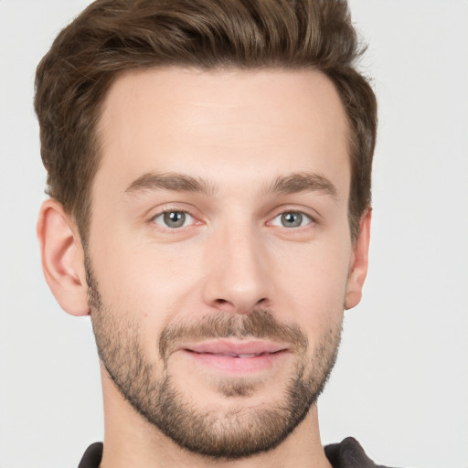 Joyful white young-adult male with short  brown hair and grey eyes