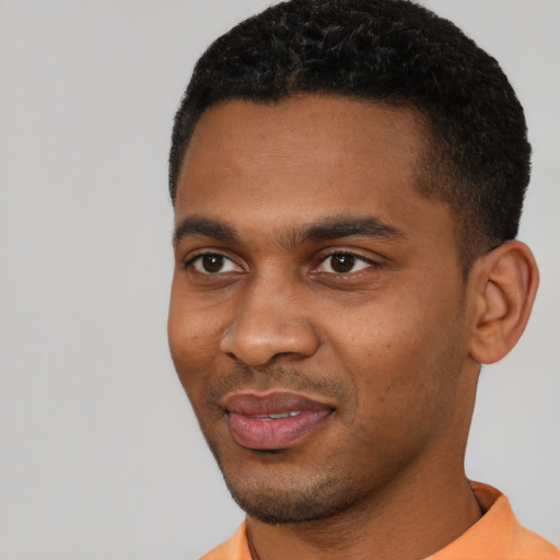 Joyful black young-adult male with short  black hair and brown eyes