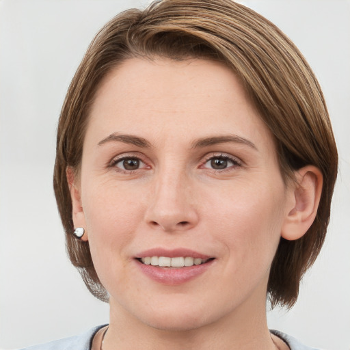 Joyful white young-adult female with medium  brown hair and grey eyes