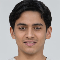 Joyful latino young-adult male with short  brown hair and brown eyes