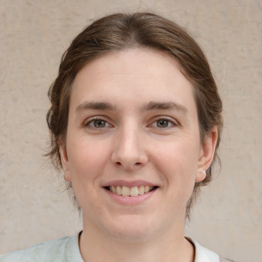 Joyful white young-adult female with medium  brown hair and green eyes