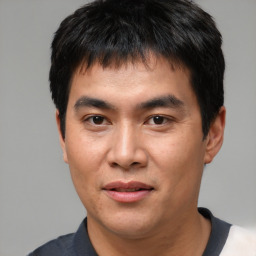 Joyful asian young-adult male with short  black hair and brown eyes