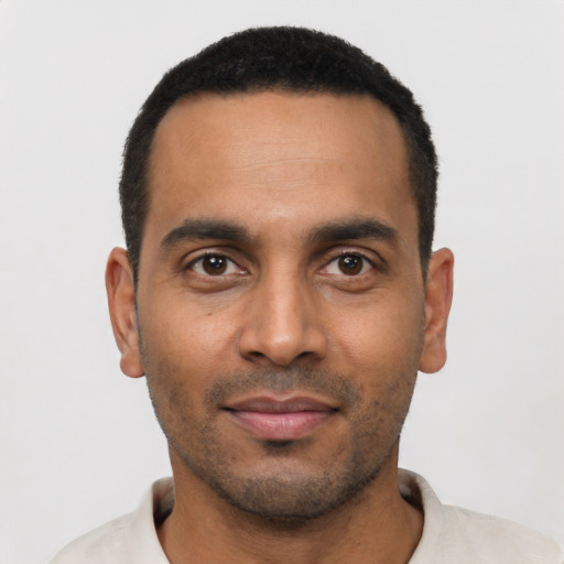 Joyful latino young-adult male with short  black hair and brown eyes