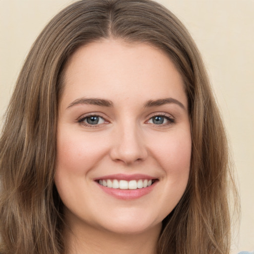 Joyful white young-adult female with long  brown hair and green eyes