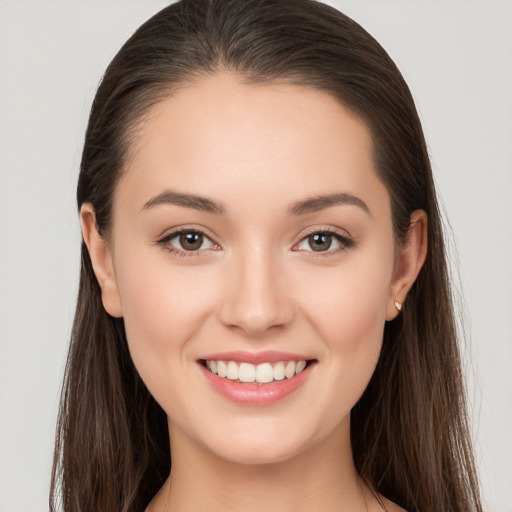 Joyful white young-adult female with long  brown hair and brown eyes