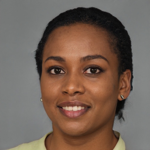 Joyful black young-adult female with short  black hair and brown eyes