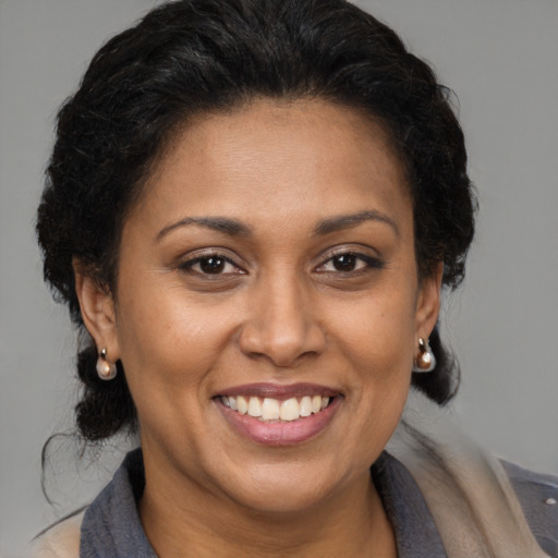 Joyful latino adult female with medium  brown hair and brown eyes