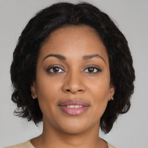 Joyful black adult female with medium  brown hair and brown eyes