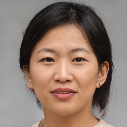 Joyful asian adult female with medium  brown hair and brown eyes