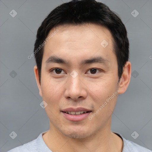 Joyful asian young-adult male with short  black hair and brown eyes