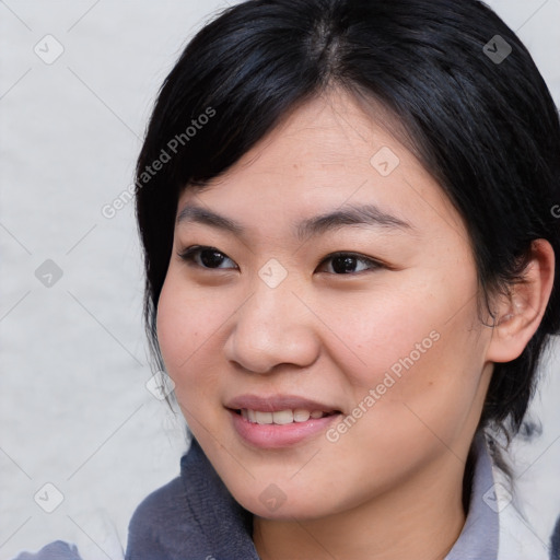 Joyful asian young-adult female with medium  black hair and brown eyes