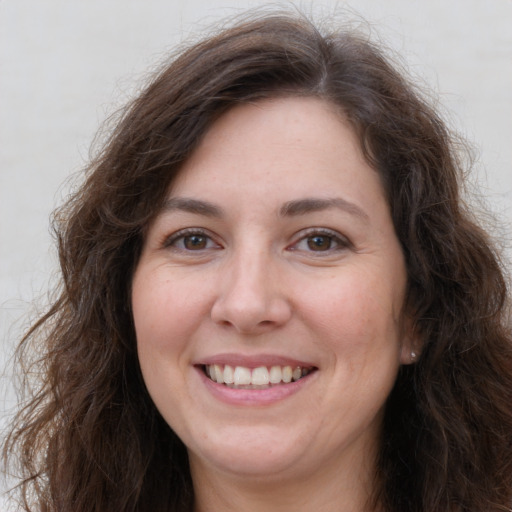 Joyful white adult female with long  brown hair and brown eyes