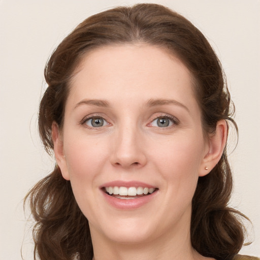 Joyful white young-adult female with long  brown hair and blue eyes