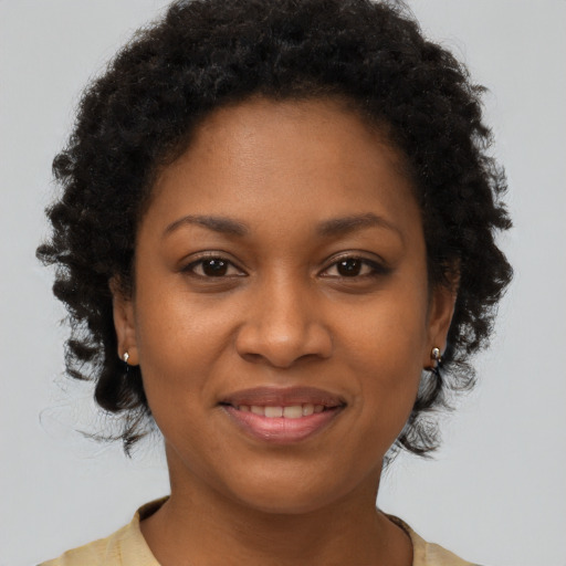 Joyful black young-adult female with short  brown hair and brown eyes
