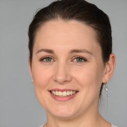 Joyful white young-adult female with medium  brown hair and grey eyes