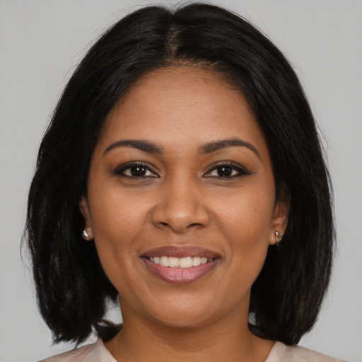 Joyful black young-adult female with medium  brown hair and brown eyes