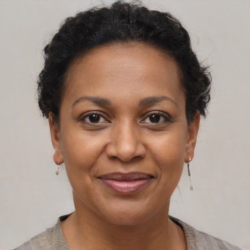 Joyful black adult female with short  brown hair and brown eyes