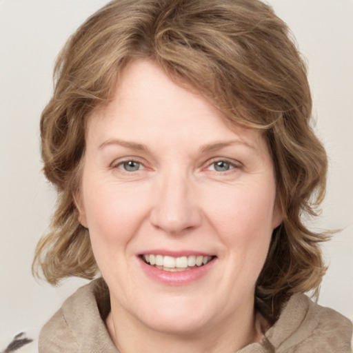 Joyful white young-adult female with medium  brown hair and blue eyes