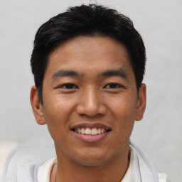 Joyful asian young-adult male with short  black hair and brown eyes