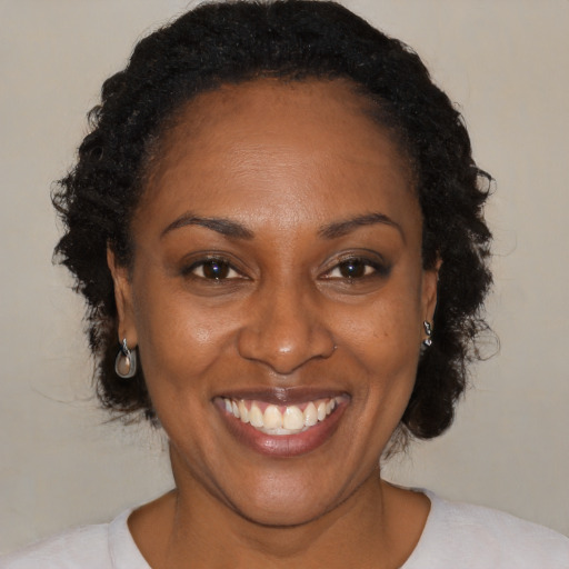 Joyful black adult female with short  brown hair and brown eyes
