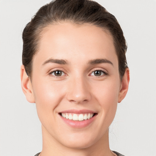 Joyful white young-adult female with short  brown hair and grey eyes