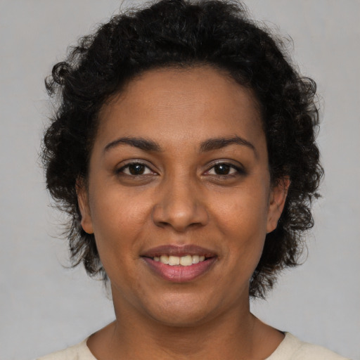 Joyful black young-adult female with short  brown hair and brown eyes