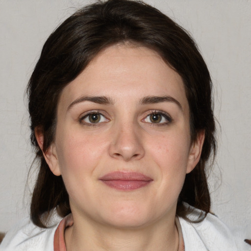 Joyful white young-adult female with medium  brown hair and green eyes