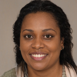 Joyful black young-adult female with long  brown hair and brown eyes