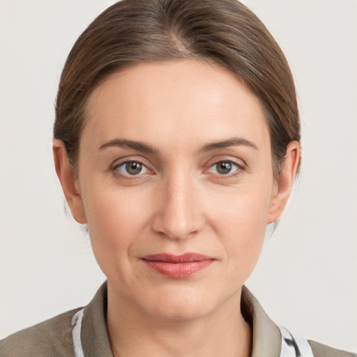 Joyful white young-adult female with medium  brown hair and grey eyes