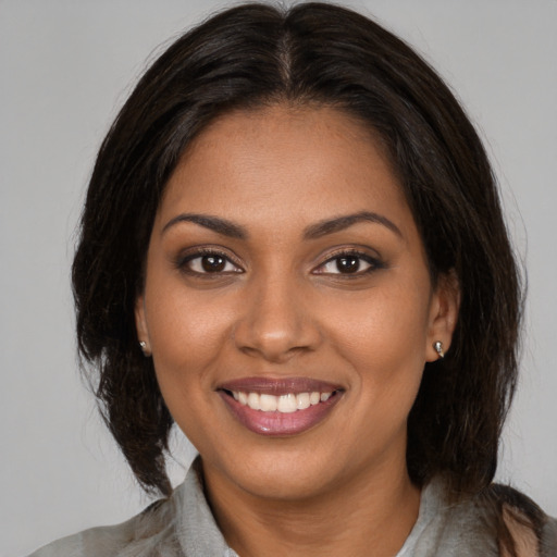 Joyful black young-adult female with medium  brown hair and brown eyes