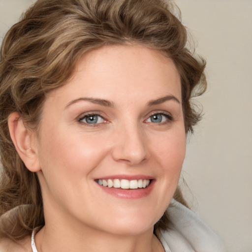 Joyful white young-adult female with medium  brown hair and blue eyes