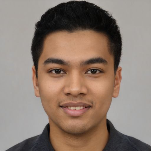 Joyful latino young-adult male with short  black hair and brown eyes