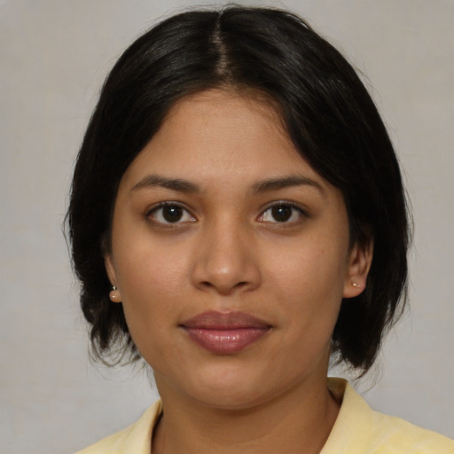 Joyful latino young-adult female with medium  brown hair and brown eyes