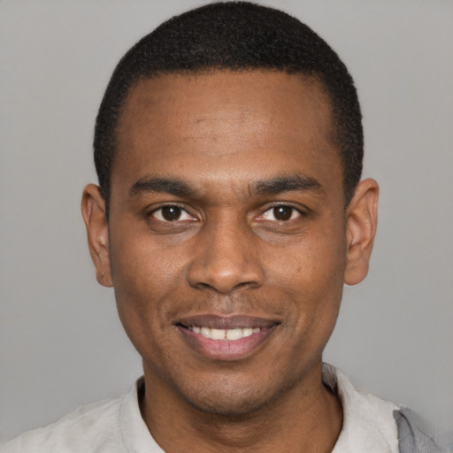 Joyful black young-adult male with short  black hair and brown eyes