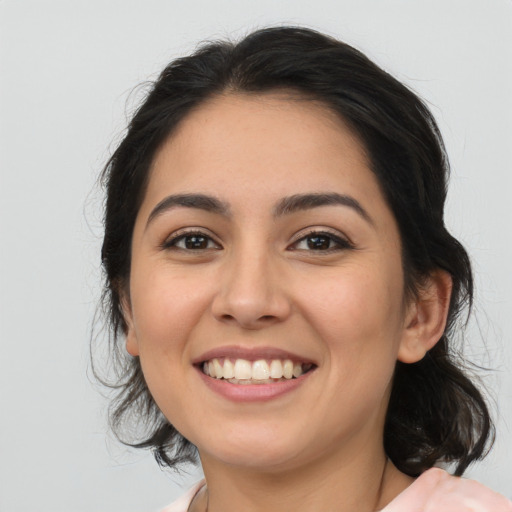 Joyful latino young-adult female with medium  brown hair and brown eyes