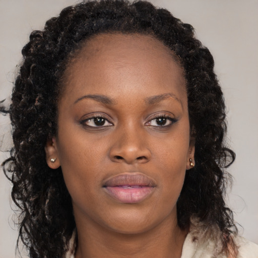 Joyful black young-adult female with long  brown hair and brown eyes