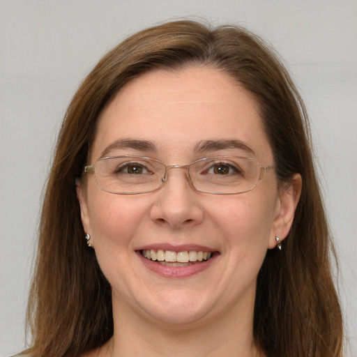 Joyful white adult female with long  brown hair and grey eyes