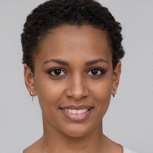 Joyful black young-adult female with short  brown hair and brown eyes