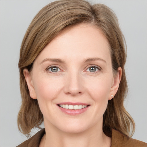 Joyful white young-adult female with medium  brown hair and grey eyes