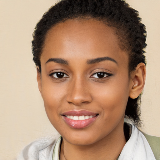 Joyful black young-adult female with short  brown hair and brown eyes