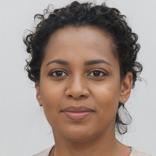 Joyful black young-adult female with short  brown hair and brown eyes