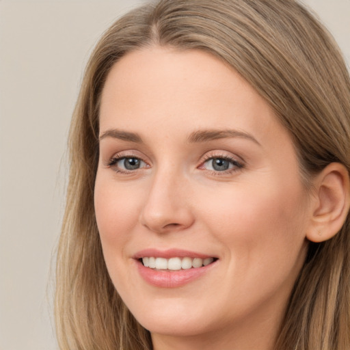 Joyful white young-adult female with long  brown hair and grey eyes