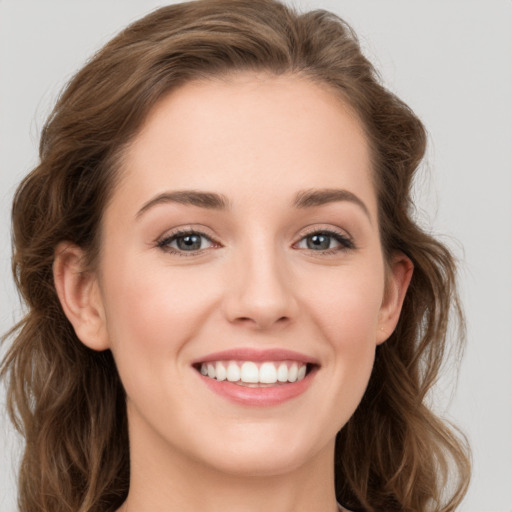 Joyful white young-adult female with long  brown hair and green eyes