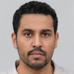 Neutral latino young-adult male with short  black hair and brown eyes
