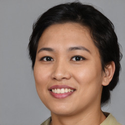 Joyful asian young-adult female with medium  brown hair and brown eyes