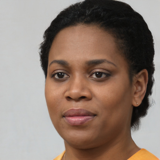 Joyful black young-adult female with short  brown hair and brown eyes