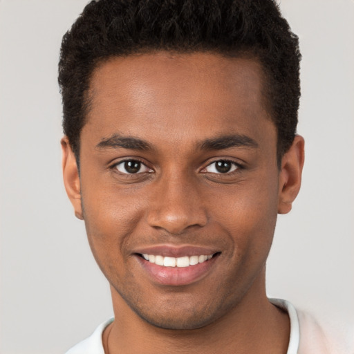 Joyful black young-adult male with short  brown hair and brown eyes